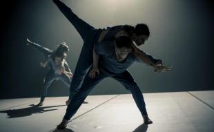 three dancers sillouetted on stage