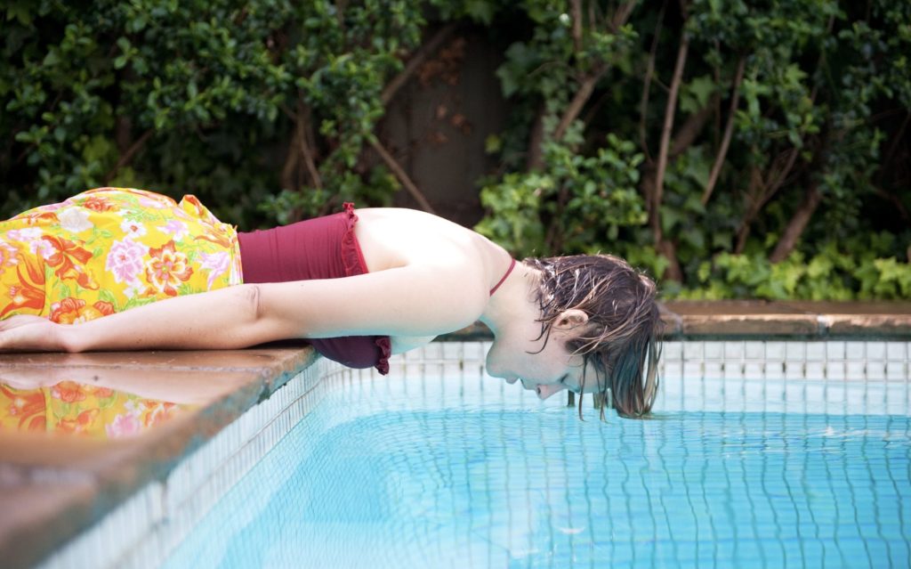 Woman looks into pool pondering future. Sarah Walker Photography.