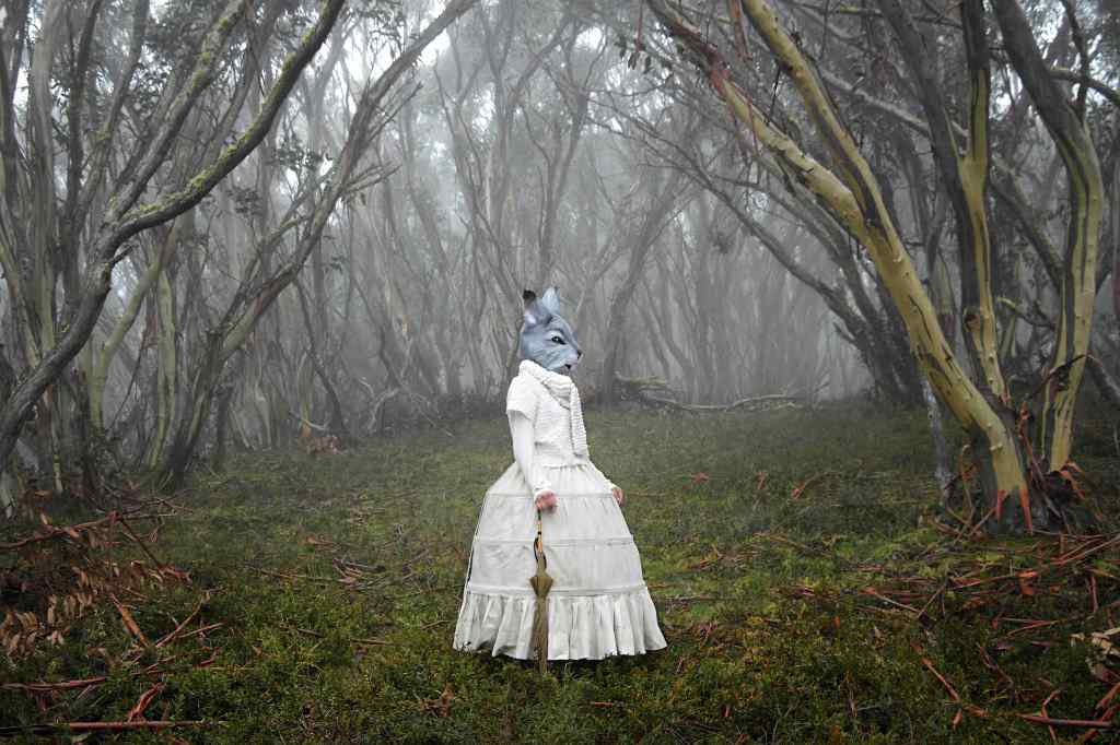 Woman in Australian bush with Victorian dress and rabbit headdress..