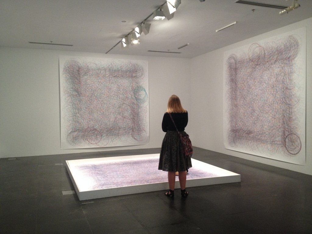 Woman in gallery looking at abstract painting.