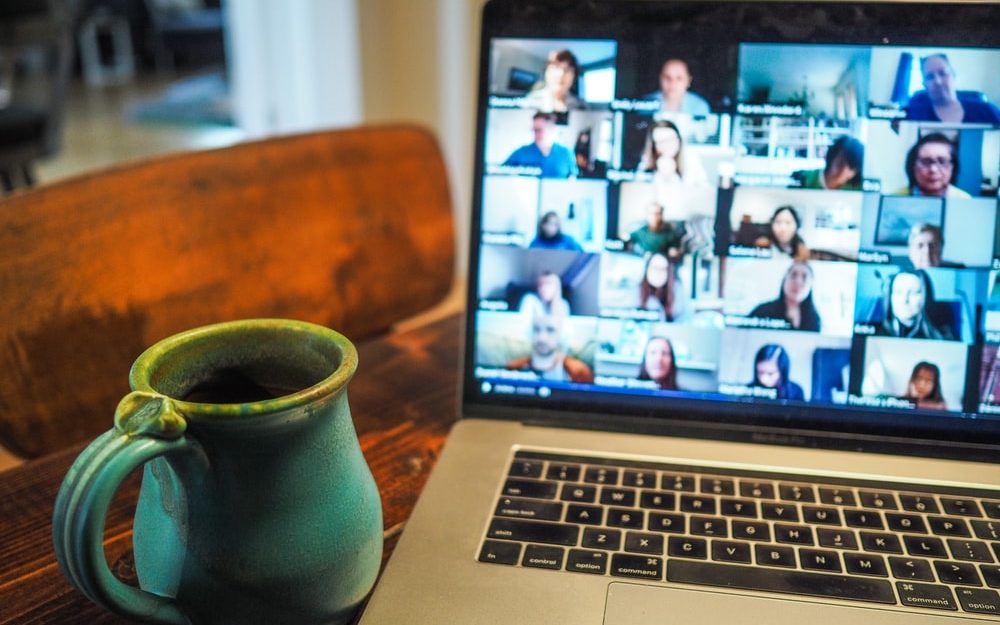 An image of a blue mug next to a laptop in a zoom meeting. 