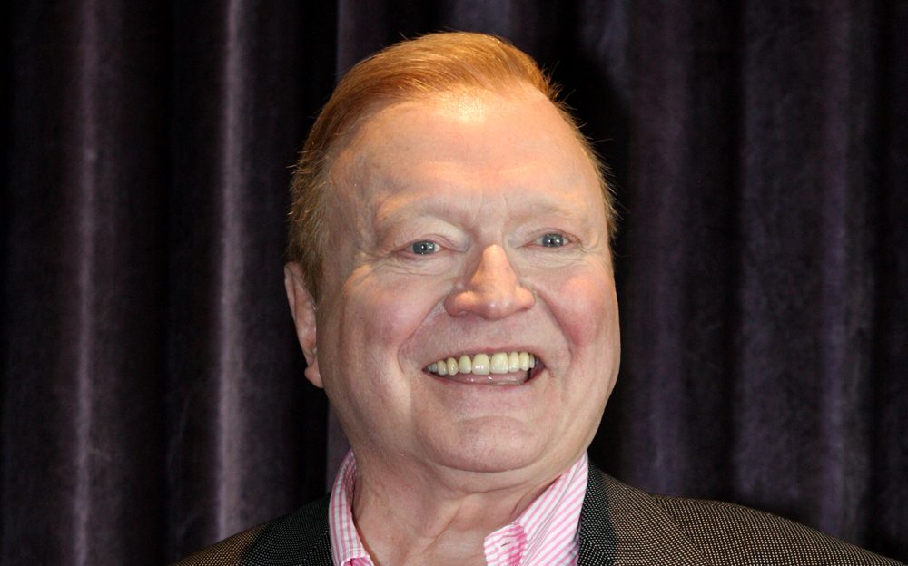 Smiling man in pink shirt and dark jacket