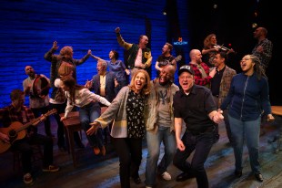 a diverse group of people on stage singing and having a good time