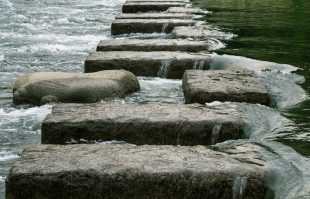 Rough stone steps lead a risky path across a fast-flowing stream.