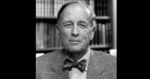 an old man in abow tie in front of a bookcase