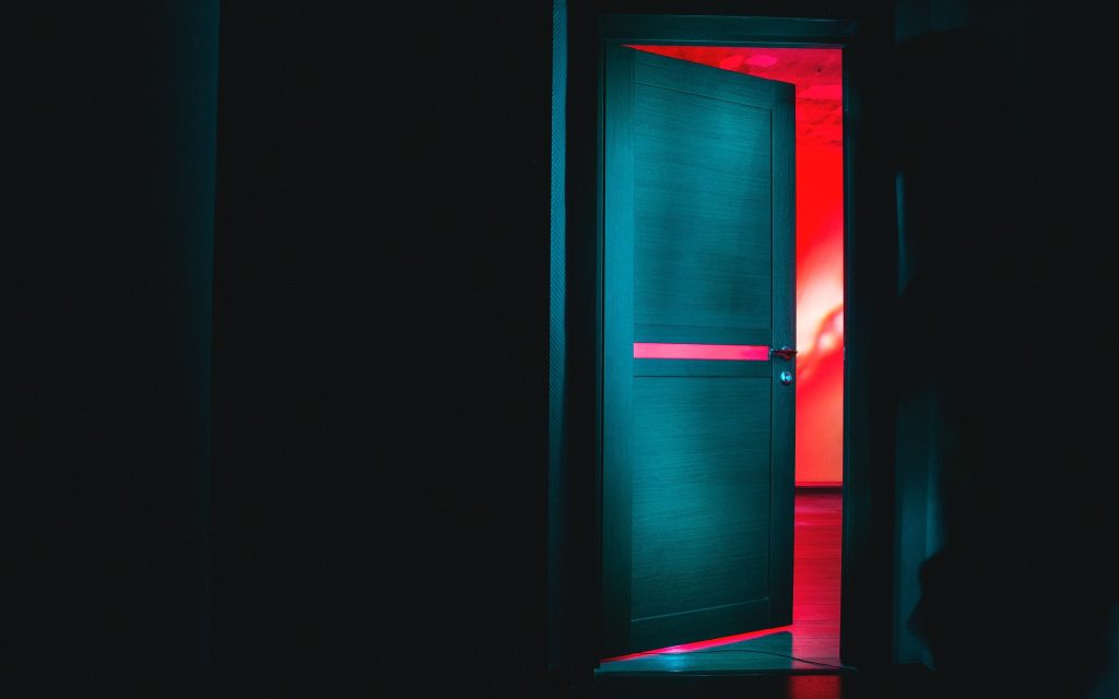 a gallery door with bright lights behind it almost closed