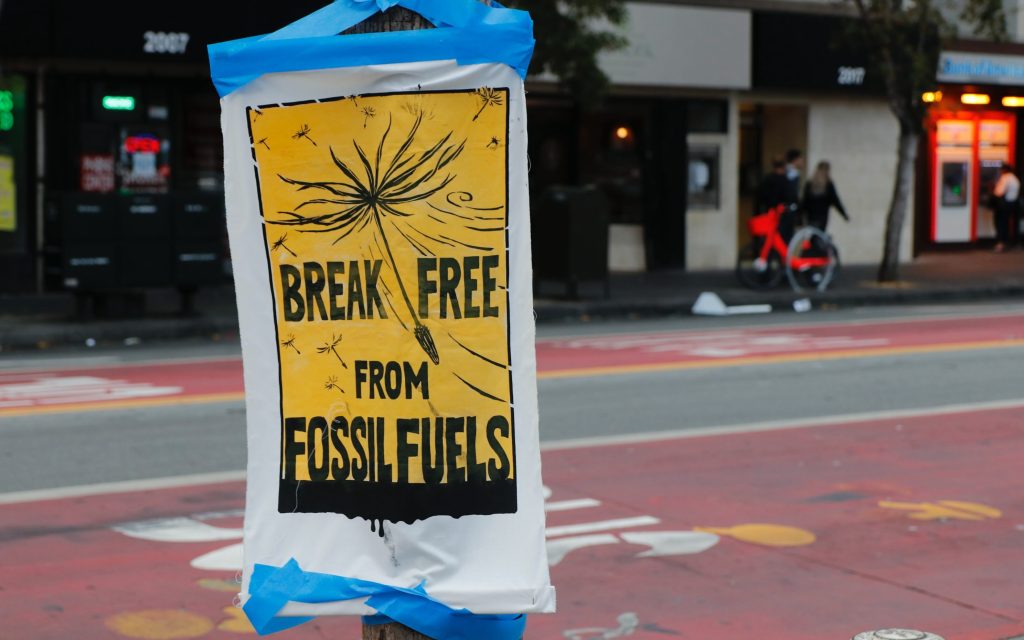 A street sign saying BREAK FREE OF FOSSIL FUELS