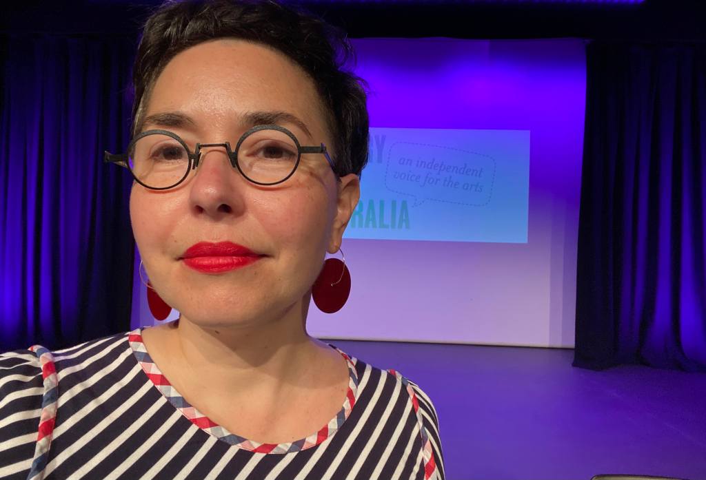 A woman (Esther Anatolitis) in front of a purple screen