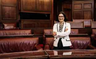 a woman standing against leather benches in Old Parliament House, Australia