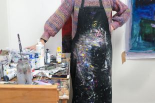 An artist's paint-splattered apron and materials