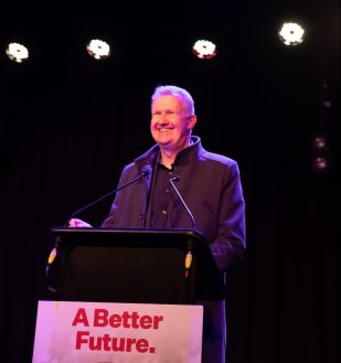 Man (Tony Burke) smiles as