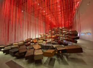 Gallery of suitcases suspended with red string by artist Chiharu Shiota.