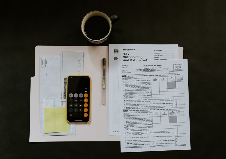 a birds-eye view of a desk with tax papers and a calculator.