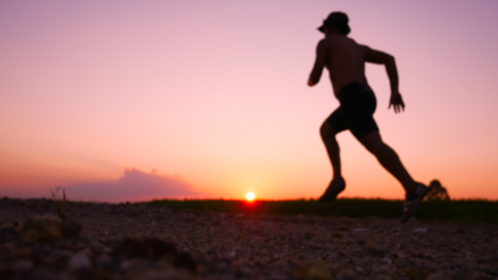 A runner's silhouette pictured against the sunset.