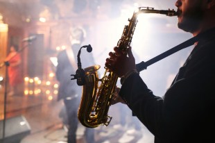 A saxophonist plays his mic'ed up instrument at a studio session.