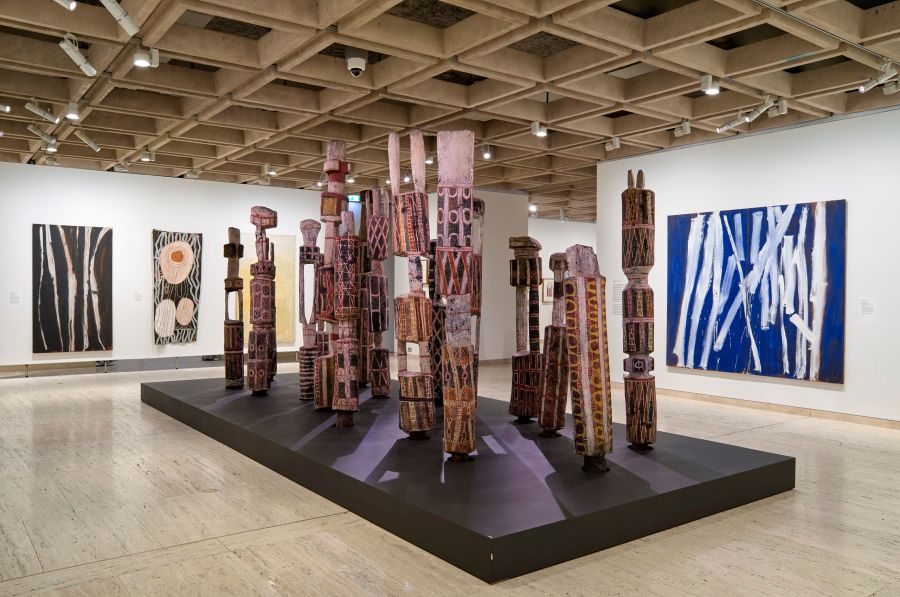 a gallery space showing an installation work by Aboriginal artists of totemic poles