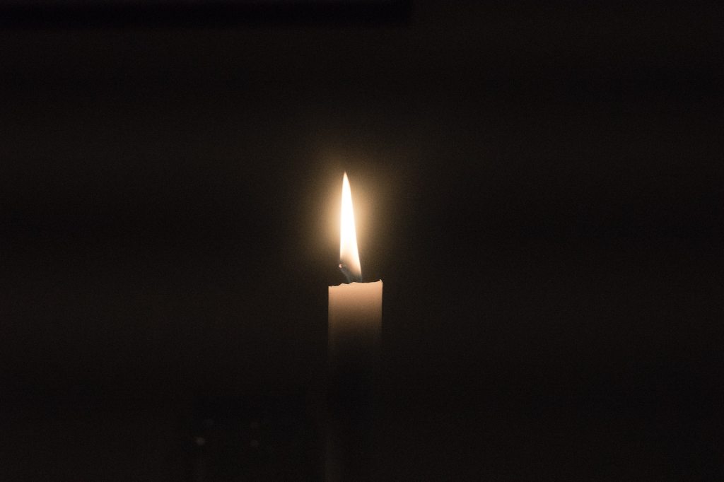 candle burning; dark interior