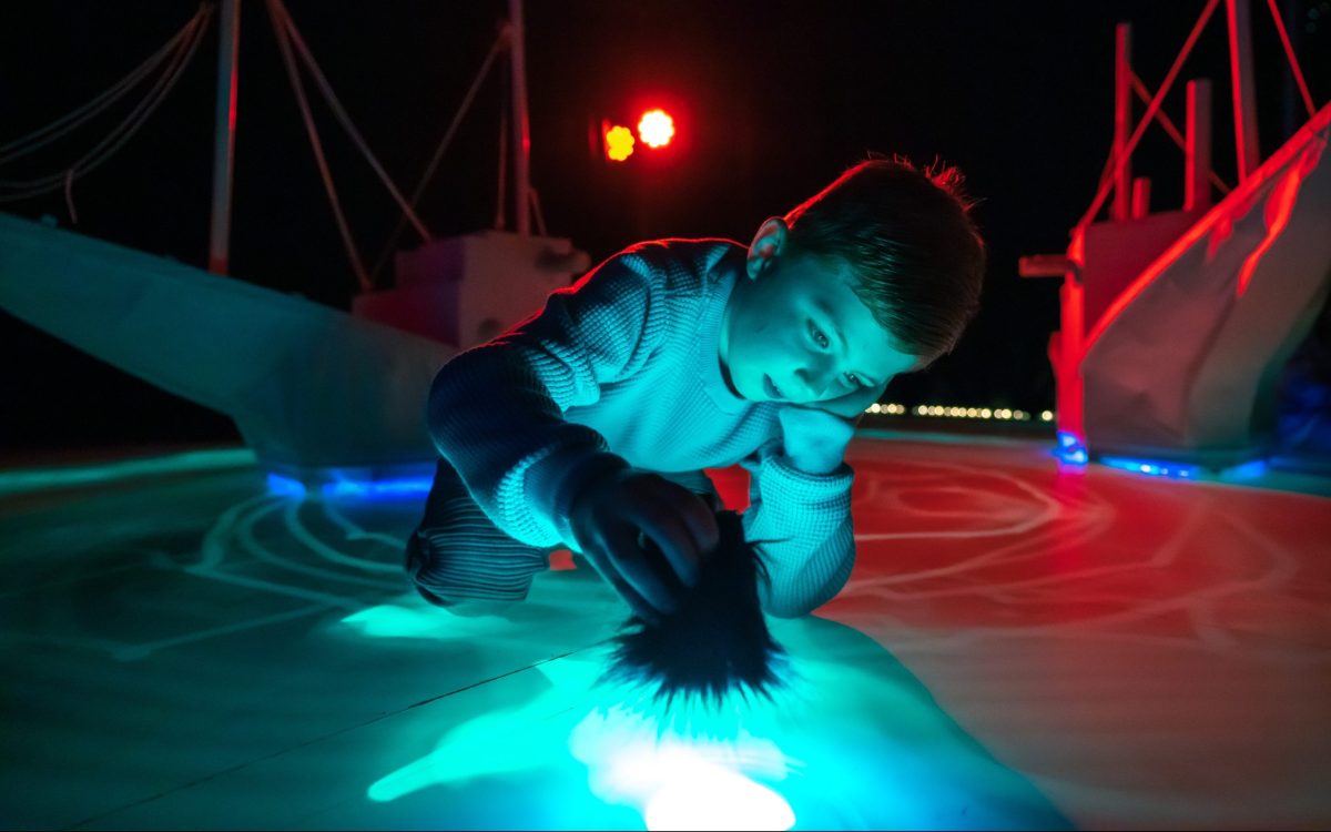 Young boy interacting with light art. arts education. DreamBIG