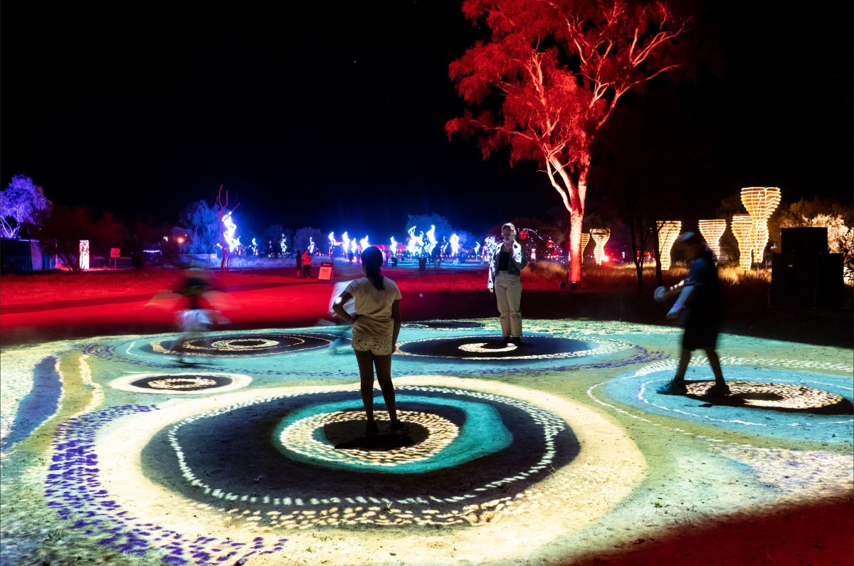 people walking around light festival of Aboriginal Art. Parrtjima