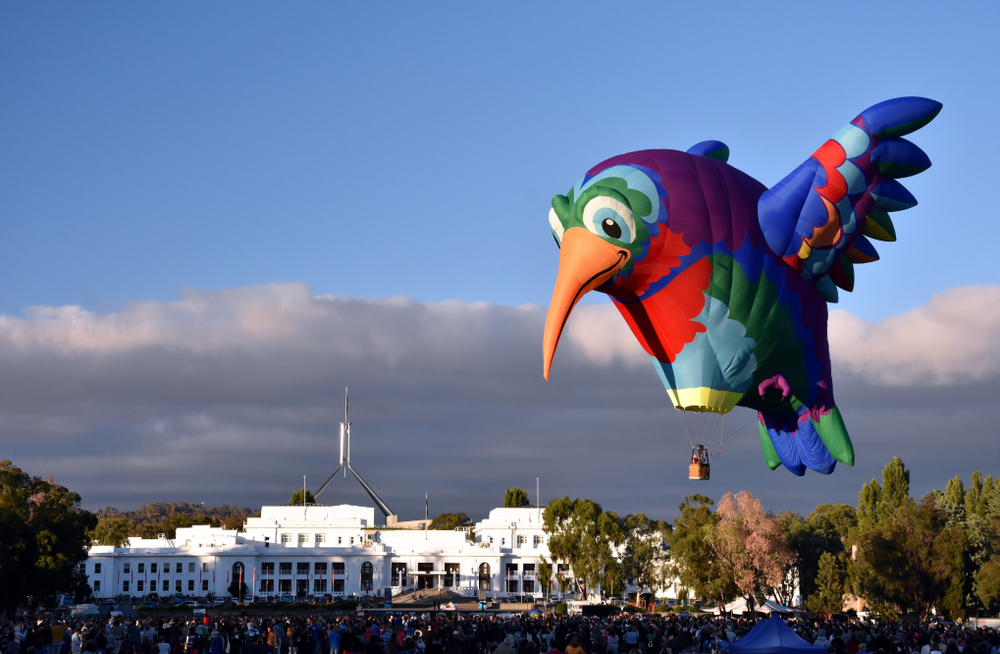 A hot air balloon in the shape of a giant, colourful hummingbird takes off from the grounds of Old Parliament House, Canberra.