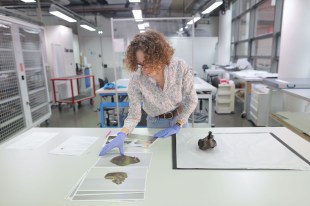 conservator examining Aboriginal artefact