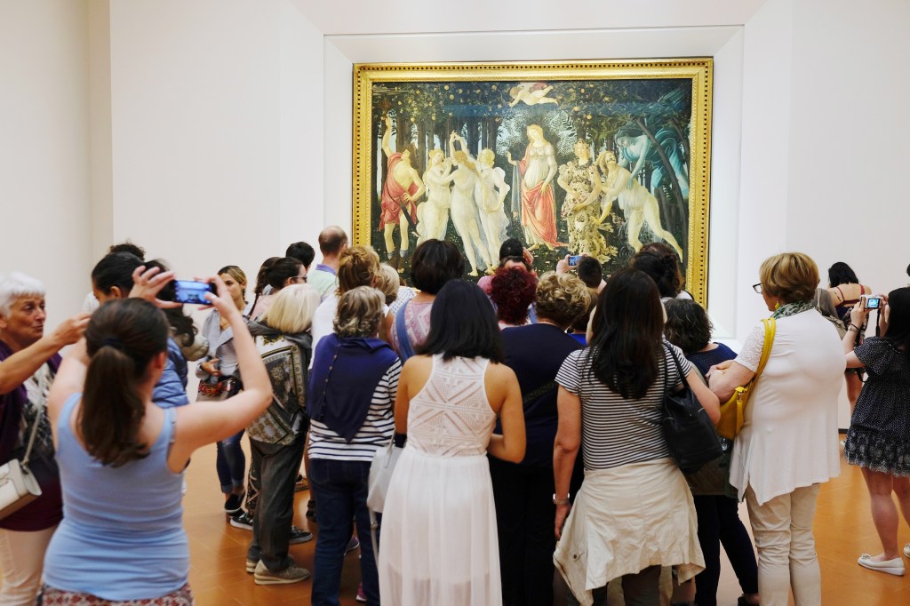 People crowding around a painting in a gallery