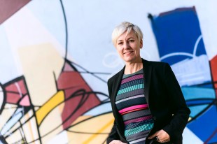 Cate Faehrmann, NSW Greens' Arts Spokesperson, in front of abstract painting