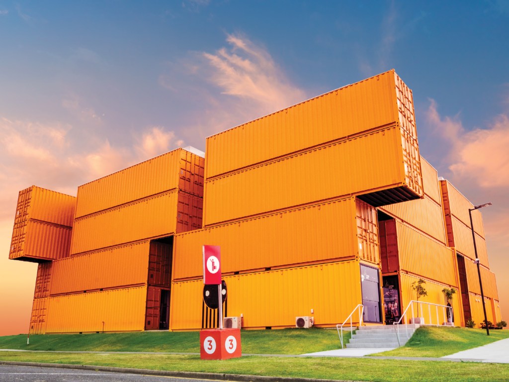 A bright orange building constructed from multiple shipping containers.