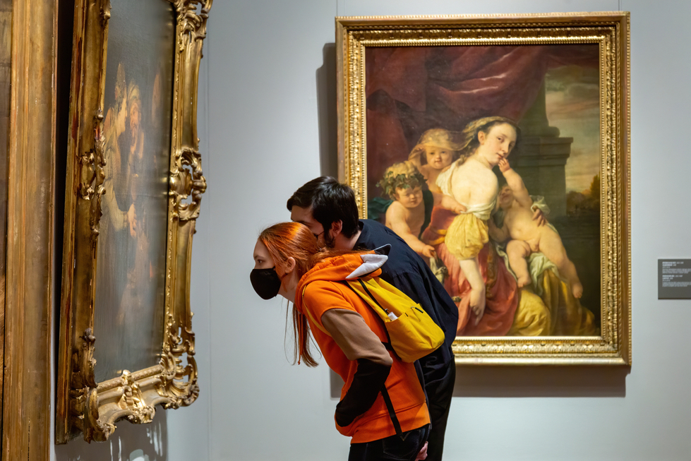 people reading the wall labels in an art gallery