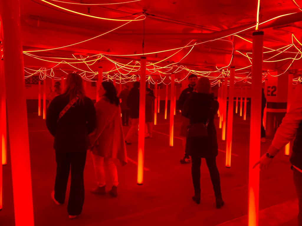 People in immersive red light art installation for Vivid Sydney.
