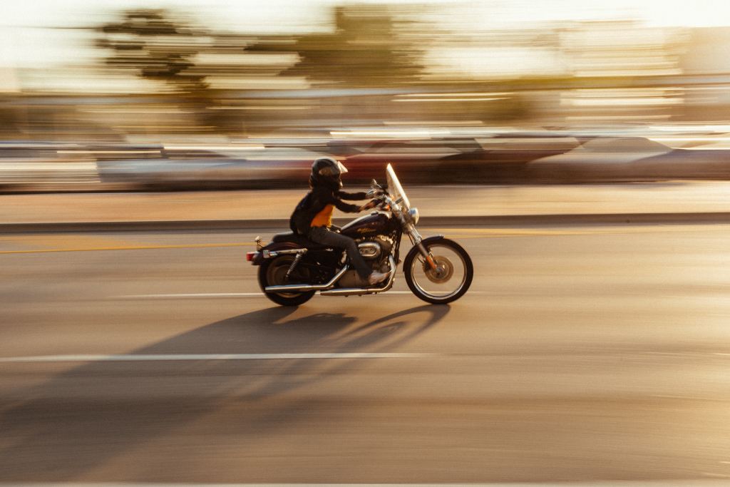 A speeding motorbike captured in a photograph; it and its rider are cleanly shot while the background is blurred, indicating the bike's speed.