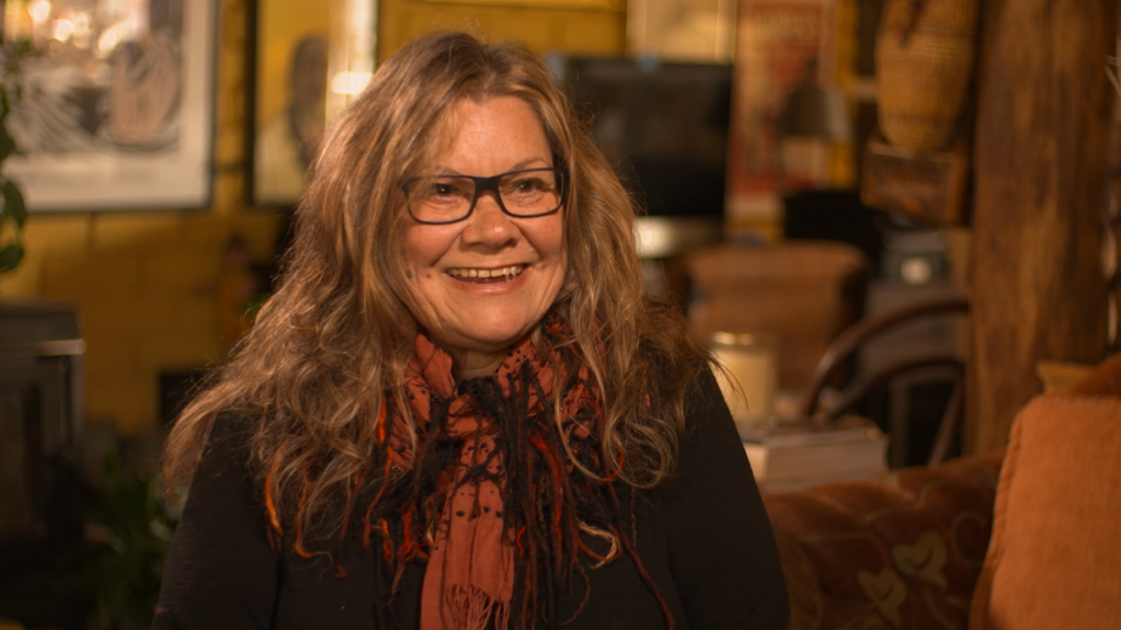 image of Aboriginal artist Sandra Hill, smiling in her home