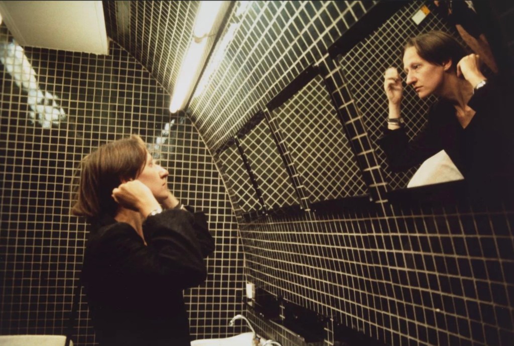 Nan Goldin photography of woman looking in bathroom mirror