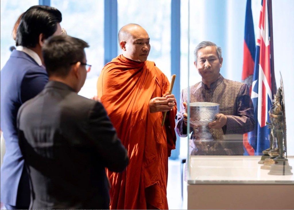 Cambodian monks blessing sculptures in gallery setting