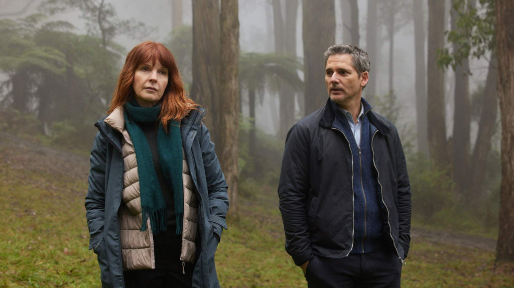 Australian novels in film. Image shows a woman in a blue coat and man in a black jacket walking in the misty woods.
