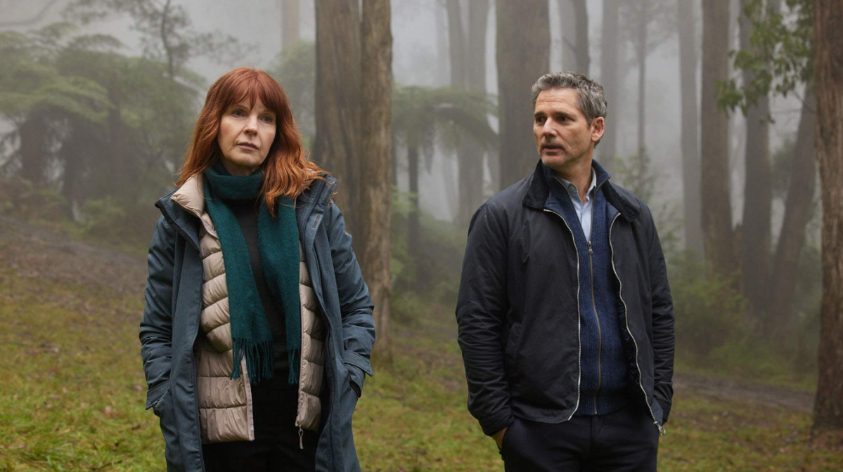 Australian novels in film. Image shows a woman in a blue coat and man in a black jacket walking in the misty woods.