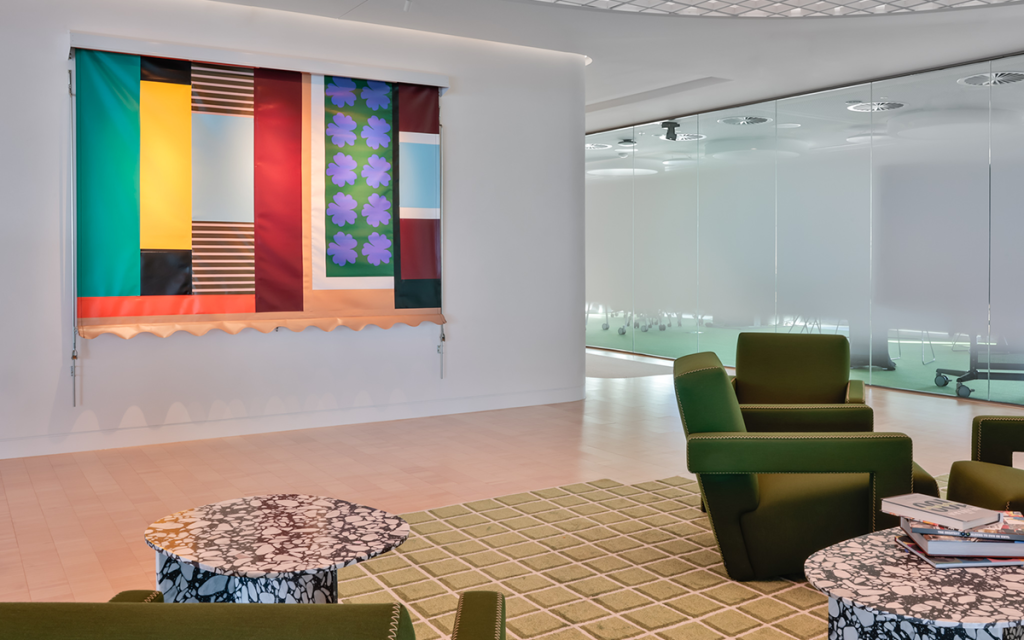 Deloitte x Art Pharmacy collection. A painting of bold coloured blocks is on the wall with chairs and tables in the foreground.