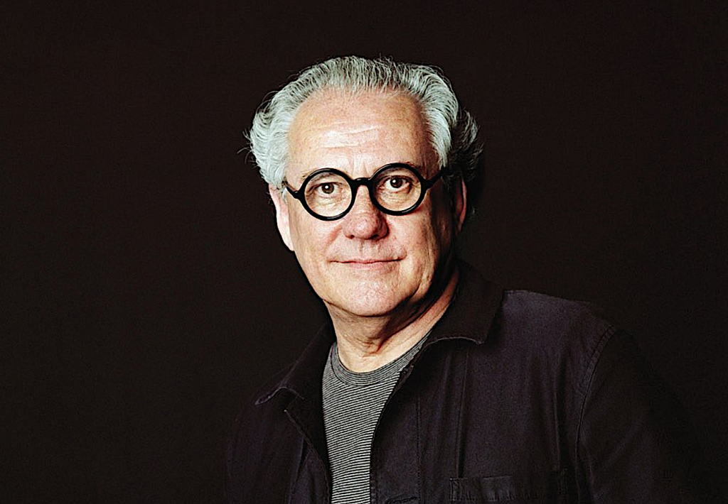 Vale Ted Snell. Creative looking elderly man with black glasses and photographed against a black background.