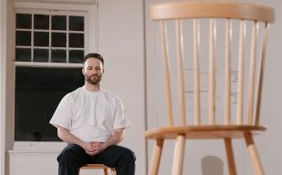 Access. Image is a man in a white T-shirt and dark trousers sitting in a chair with his eyes closed opposite another empty chair.