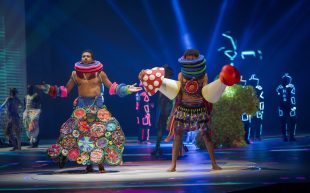 WOW. Image is of a group of people all wearing extreme, colourful and wildly inventive costumes.