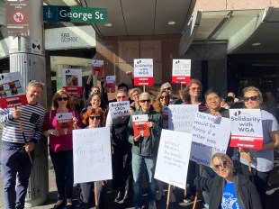 writers guild. Image shows group of people holding placards and facing camera.