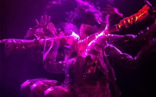 Enemies of Grooviness. Image is multiple moving bodies, blurred and lit by purple light.