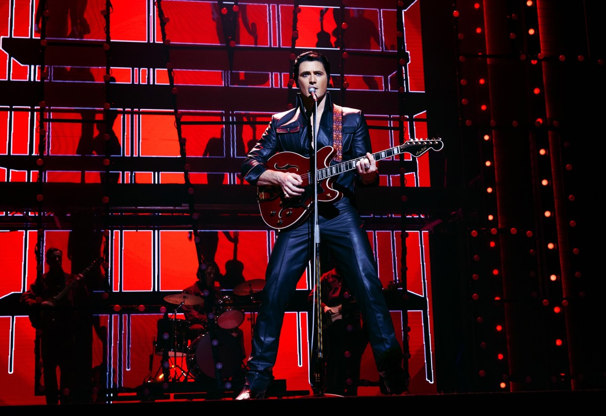 Elvis. Man in black leather playing guitar.