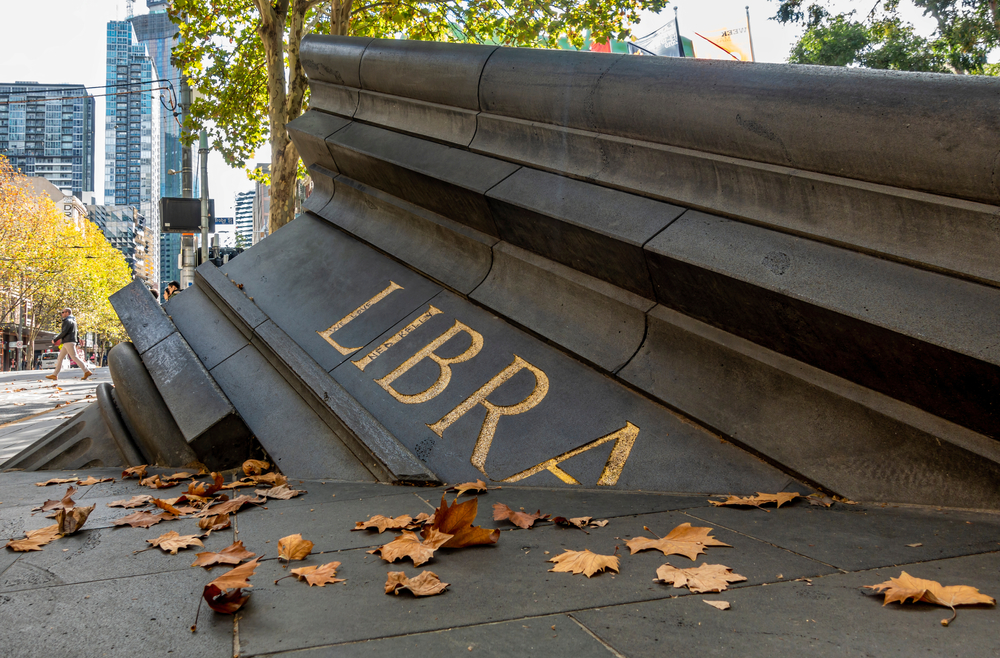 Reading. outdoor sculpture is a part of a building broken with the word library on it.