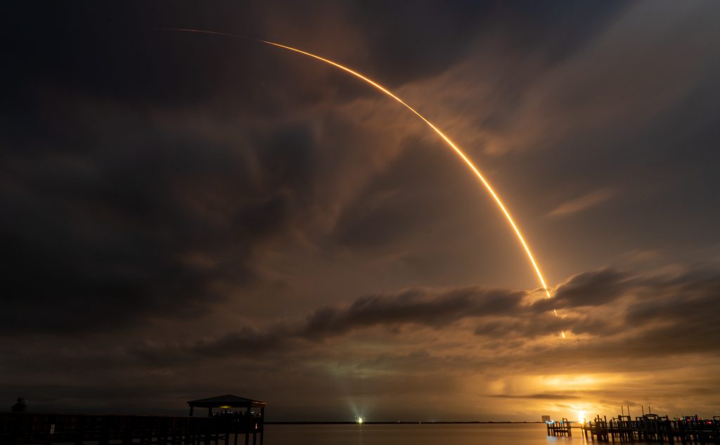 appointments. A time-lapse photo of a rocket launch at Cape Canaveral: the rocket's trajectory traces a firey arc across the evening sky.