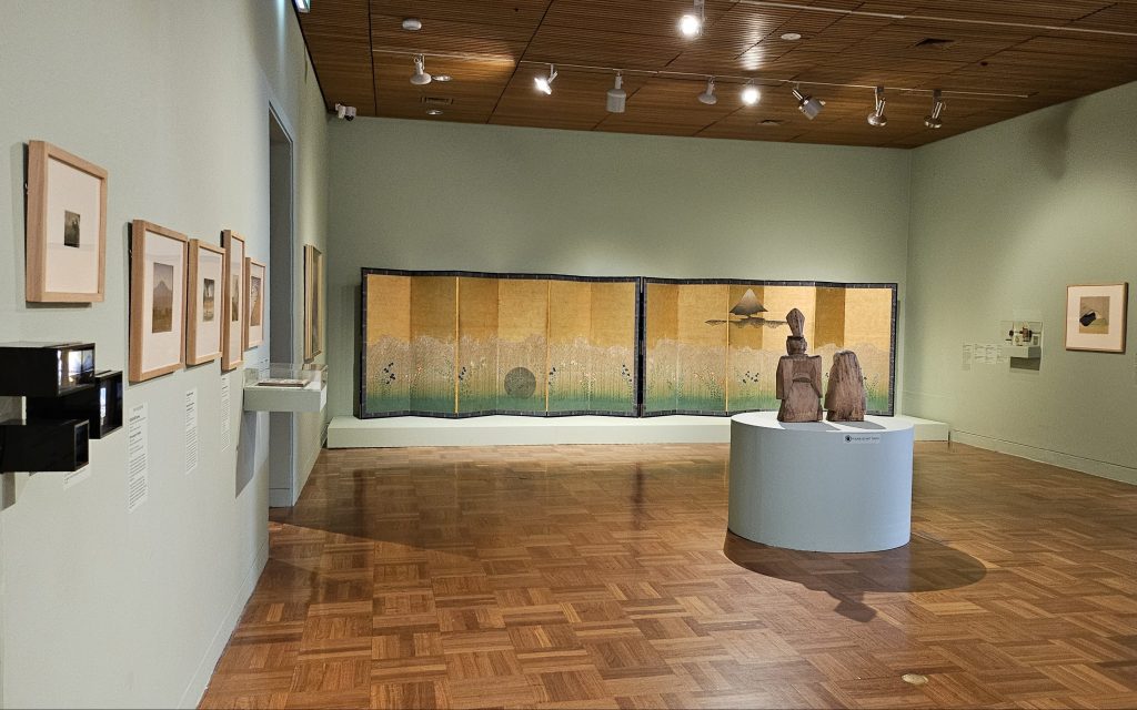 Japanese. Image is of a gallery space with Japanese images related to the country's landscape and other artefacts on display.