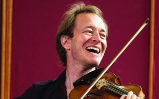 ecstasy. Image is a widely smiling man in a black shirt playing the violin.