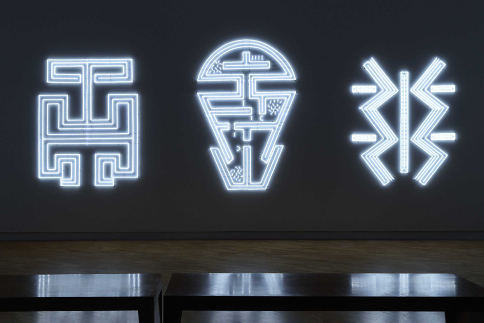 Biennale. Image is white hieroglyphic/language shapes on a dark background.