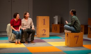 Welcome to Your New Life. Image is of three people sitting in a Play School like set, a man and a woman on a couch, looking expectant and listening intently, and a third person on a cube with the number 7 on the side talking to them.