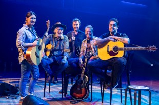 Song Circle. Image is five First Nations musicians standing and sitting on stage, four men, one woman and some guitars.